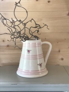 Susie Watson pink roses jugs with twisted hazel on wooden shelf