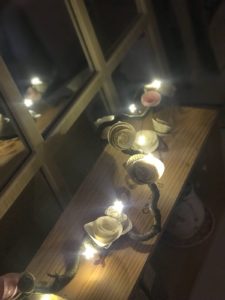 paper roses on branch with fairy lights on wooden box at night