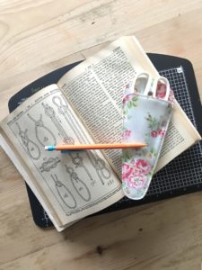 Vintage book, pencil, scissors and cutting board to make paper roses