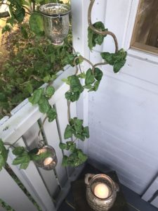 twisted hazel and tealights on grey shepherds hut veranda