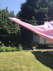 pink table cloth on outside clothes line in blue skies