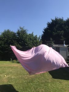 pink table cloth on outside clothes line in blue skies