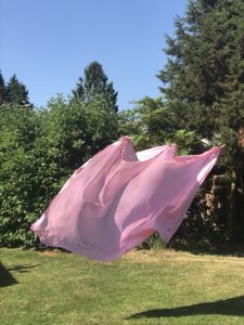 pink table cloth on outside clothes line in blue skies