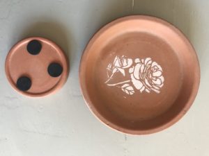 terracotta dishes with protective pads and flower stencil decoration