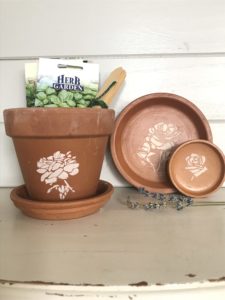 terracotta pot and dishes with flower stencils as pot decoration and garden seeds for gift