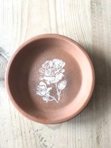 terracotta dish with flower stencil decoration