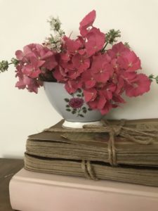 fresh cut flowers in simple flower arrangement with vintage and pink books