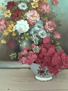 fresh cut flowers in simple flower arrangement with vintage floral painting