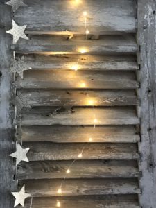 rustic shutters with star garland and lights create vintage home decor