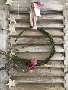 rustic shutters with simple rose wreath and lights and paper garland create shabby chic wall decor - farmhouse shutters