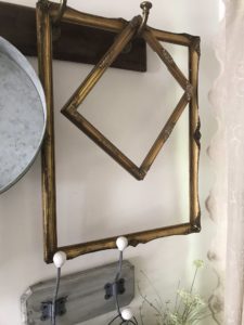 empty frames used as hanging decorations on rustic coat hooks