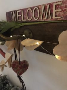 welcome sign and hanging decorations on decorative coat hooks