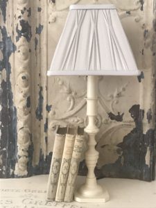 candlestick lamp with grey shade and french books creates home lighting ideas