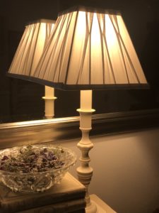 illuminated candlestick lamp with grey shade, mirror and dried flowers creates home lighting ideas