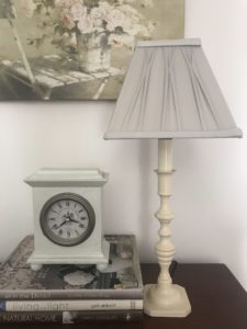 candlestick lamp with grey shade, clock books and picture creates home lighting ideas