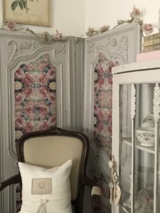 decoupage on wood on antique armoire doors to create shabby chic wall decor with chair and china cabinet