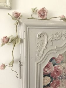 painted detail on antique armoire door with decoupage on wood and faux rose garland