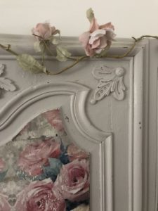 painted detail on antique armoire door with decoupage on wood and faux rose garland