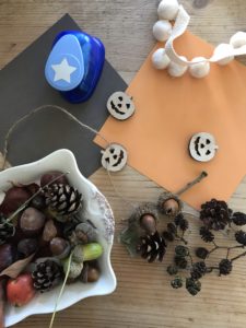 autumn crafts - creating a star garland with pom poms, mini wooden pumpkins and foraged finds