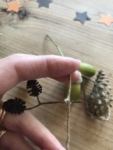 autumn craft detail gluing foraged finds to string to create autumn decor