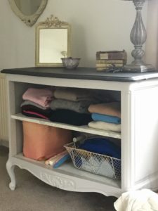 painted linen storage cabinet with jumpers, clothing, mirror and detail in bedroom