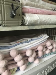 linens, throws, box, basket inside linen storage cabinet