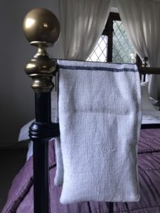 lavender rice bag over brass and iron bedstead in pretty bedroom