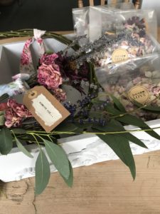 various dried flower crafts in white box with labels and eucalyptus