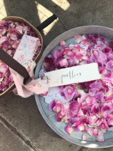 dried pink rose petals in trug and vintage dish and label for use in dried flower crafts