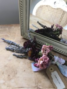 selection of tied dried flowers make a dried flower craft posy with mirror and handmade gift label