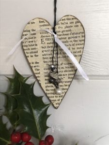 book page covered heart and trimmings make homemade tree decorations with holly sprig