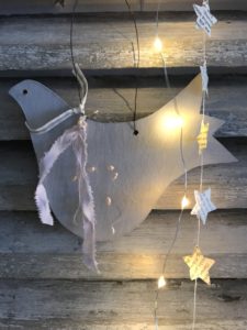 grey painted wooden christmas decoration dove and paper stars and lights