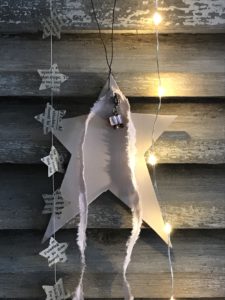 handmade pink wooden christmas decoration with rag ribbon and paper stars