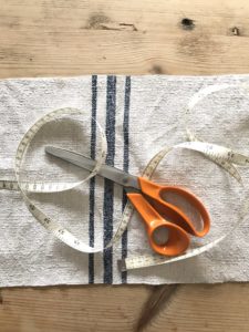 making a fabric book cover with linen scissors and measuring tape - flatlay