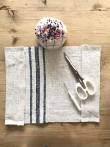 making a fabric book cover with linen and pin cushion scissors and stitch picker - flatlay