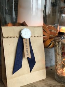 paper gift bag with clay decoration seal and blue ribbon