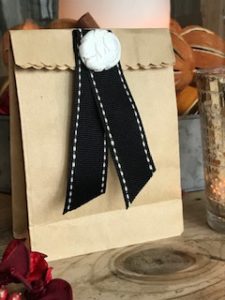 paper gift bag with clay decoration seal and black ribbon