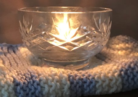 glass bowl and candle and knitted blanket