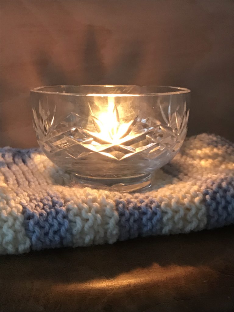 tealight in glass bowl on knitted blanket