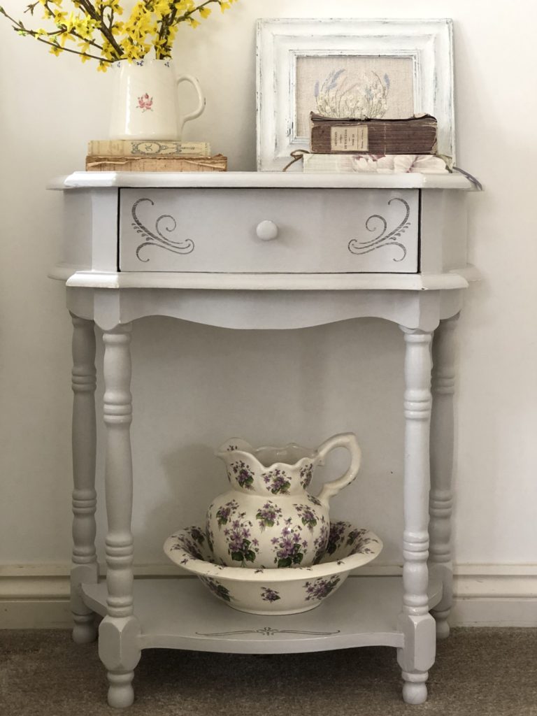 painted and stencilled bedside table with pretty jug and bowl and books