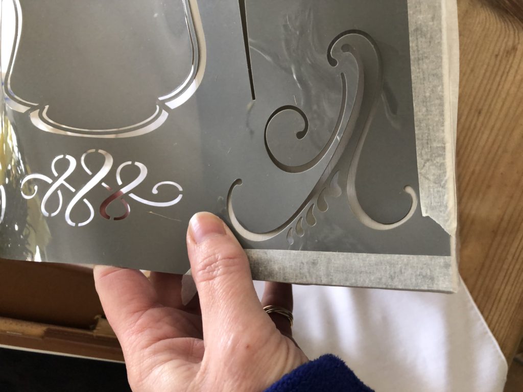 applying a stencil to  bedside table