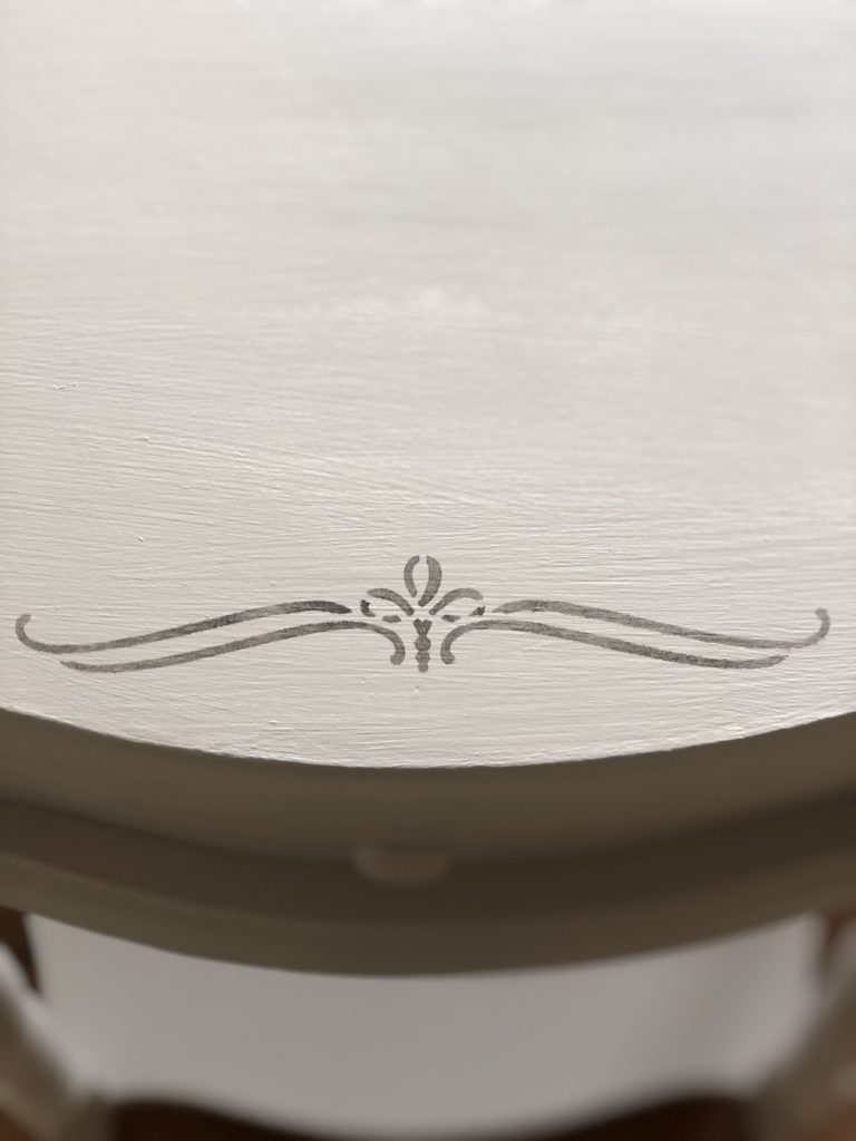 stencil scroll applied to painted table top