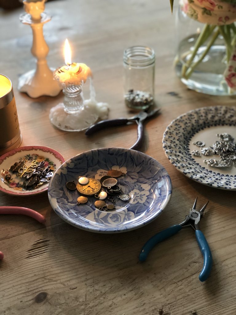 Pretty plates and trinkets on craft table used for making metal stamping decoration