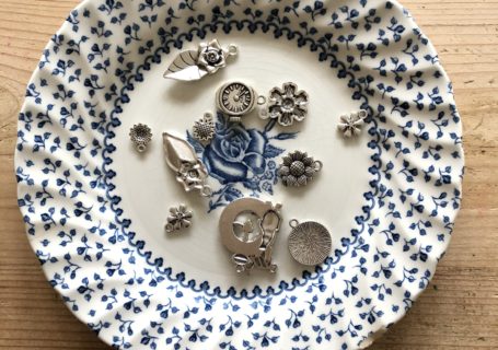 flatlay of trinkets on blue plate used for metal stamping