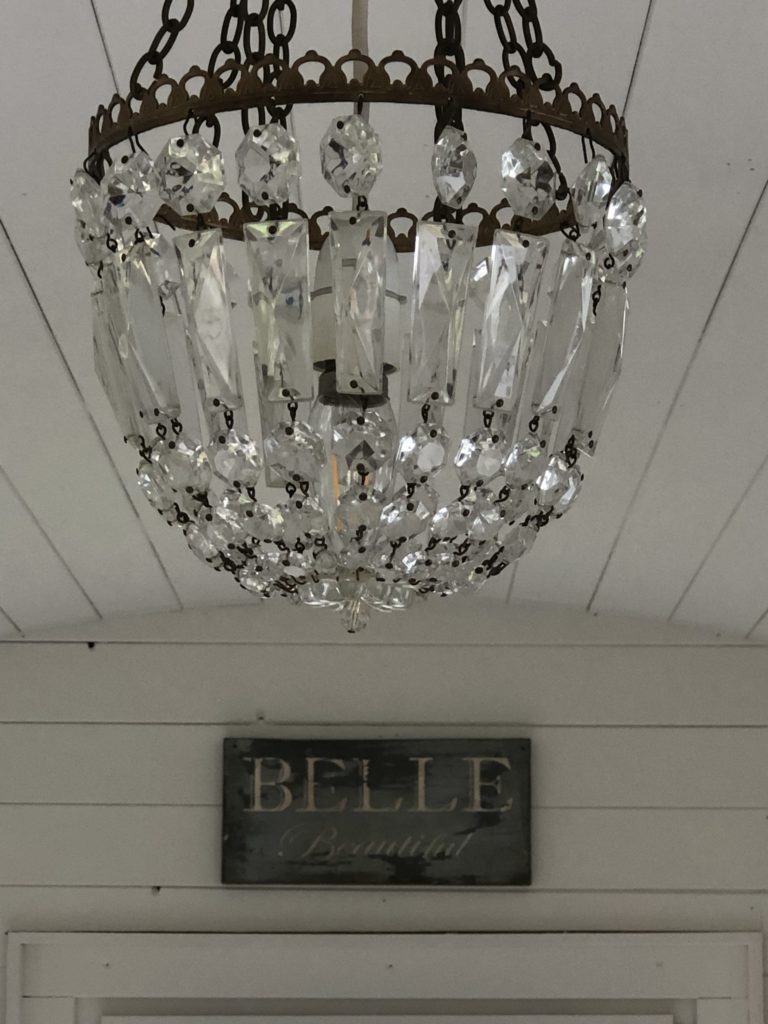 glass chandelier and rustic wooden sign