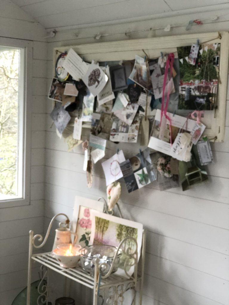 Full notice board and wire shelving with ornaments