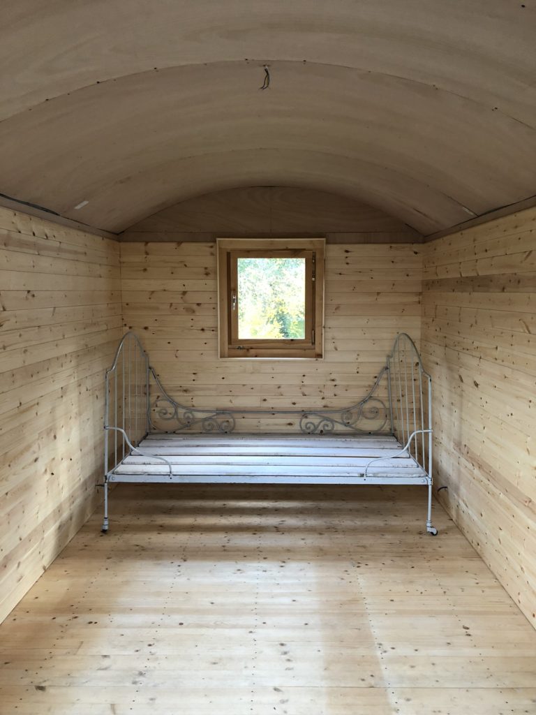 cladding the shepherds hut and a vintage iron bed