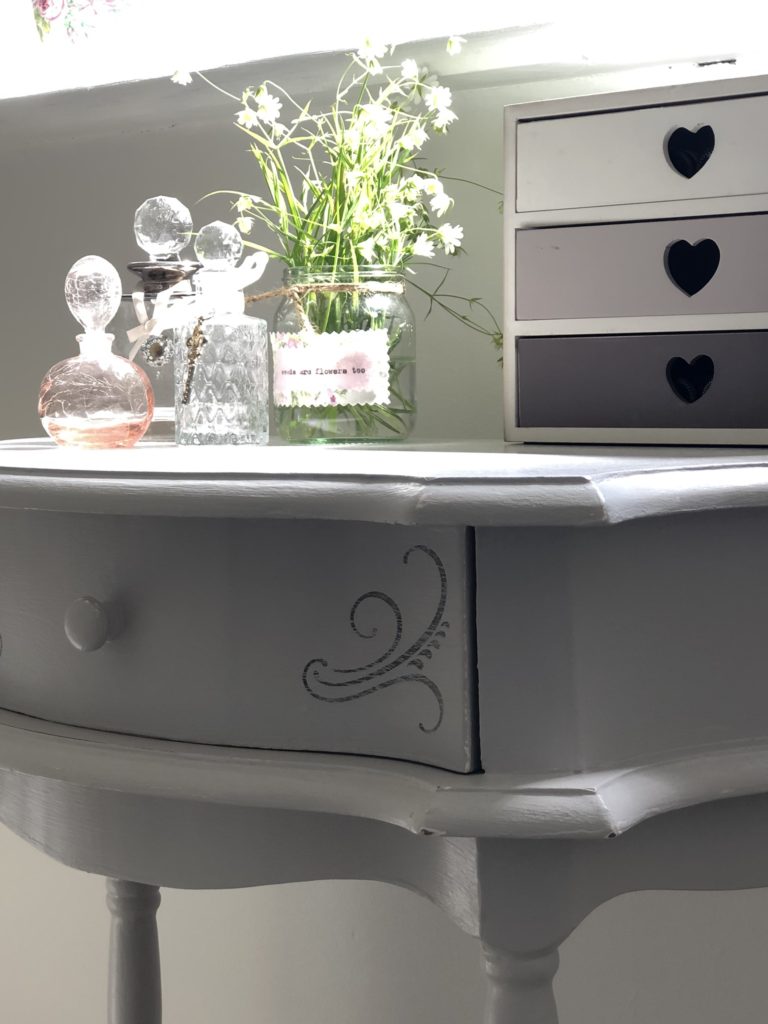 stenciled table, perfume bottles and flowers add to bathroom refresh