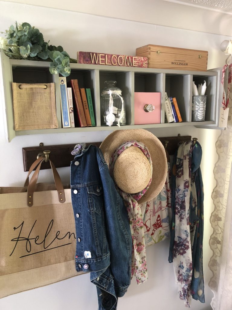 reinventing a use for cd storage unit to make a shelf with cubby holes filled with decor and filled coat hooks beneath