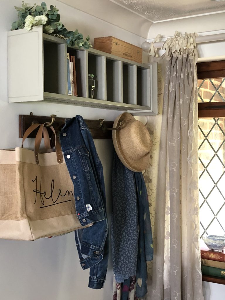 CD storage unit get a new look as a shelf for household pretties and essentials in hallway with hooks and jacket, scarves and bags hanging  beneath